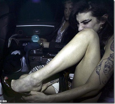 Amy Winehouse tries to smarten herself up to visit Blake in the back of a car 3