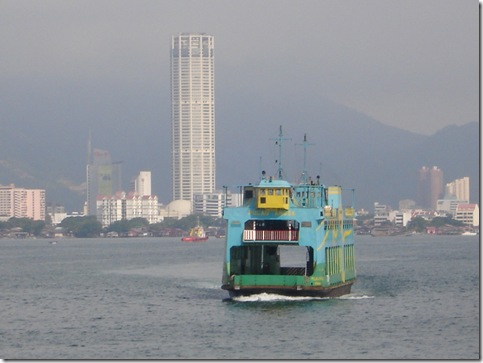 A ferry commutes between Penang island and minaland Malaysia, with Komtar (the tallest building in Penang) in the background