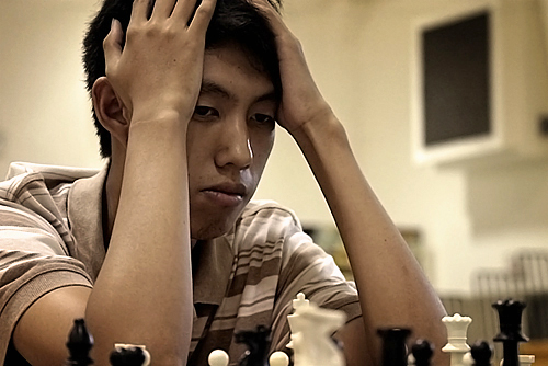 Andy Ko contemplating his next move. Regional Chess Tournament, Orange Walk Town.
